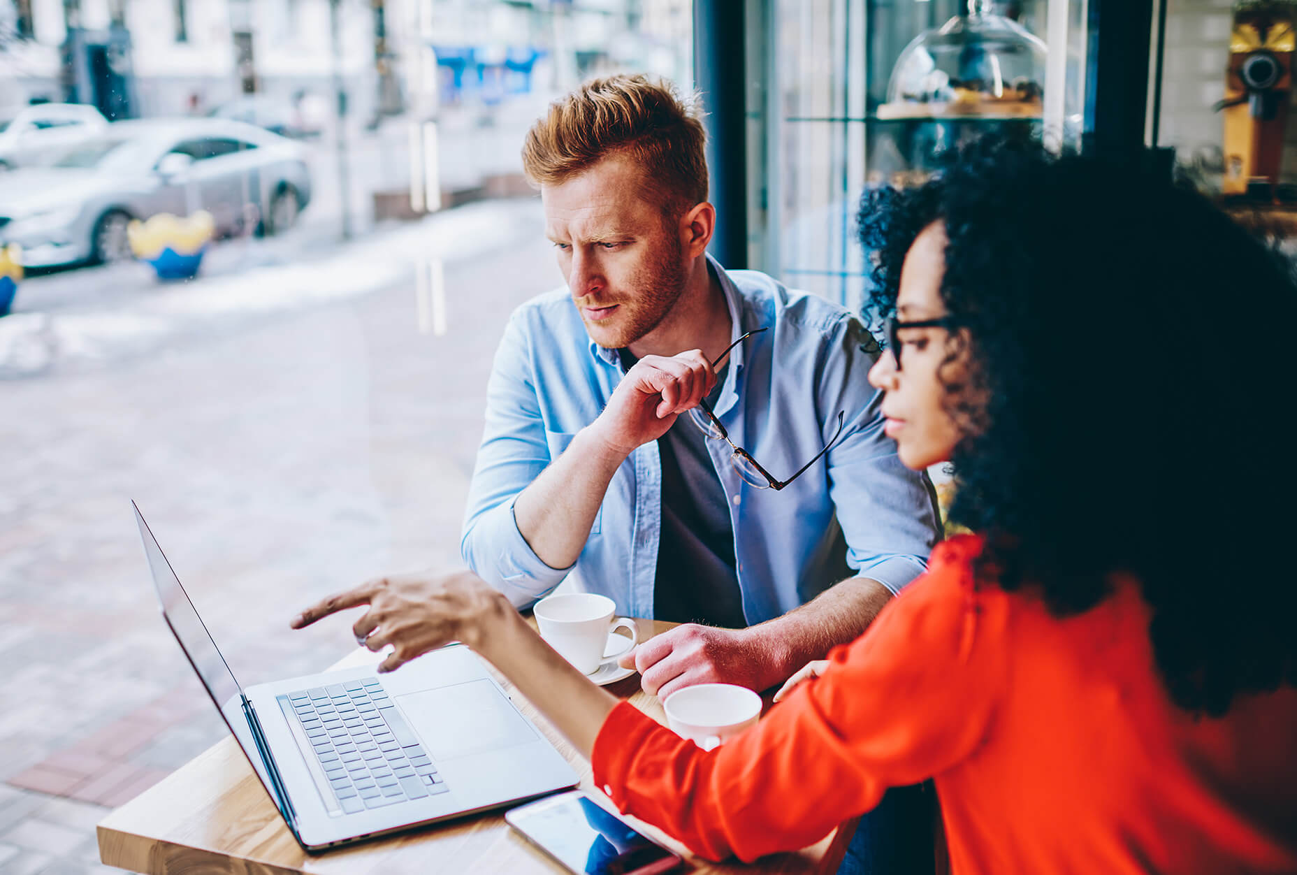 People looking at a computer in a cafe